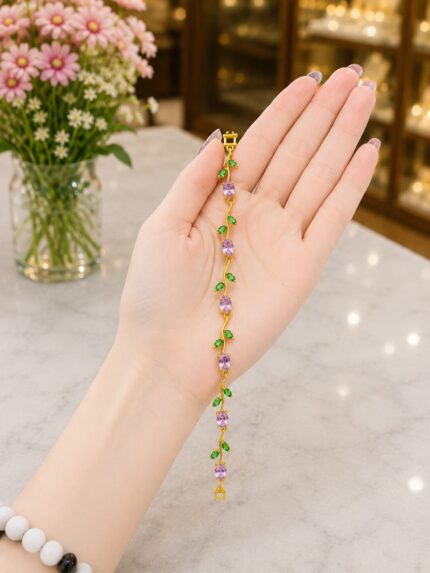 Elegant vine-inspired bracelet with sparkling purple stones and green leaf detailing in premium anti-tarnish gold polish.