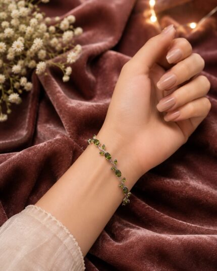 Elegant silver vine bracelet with emerald green stones and leaf detailing for a luxurious and graceful look.
