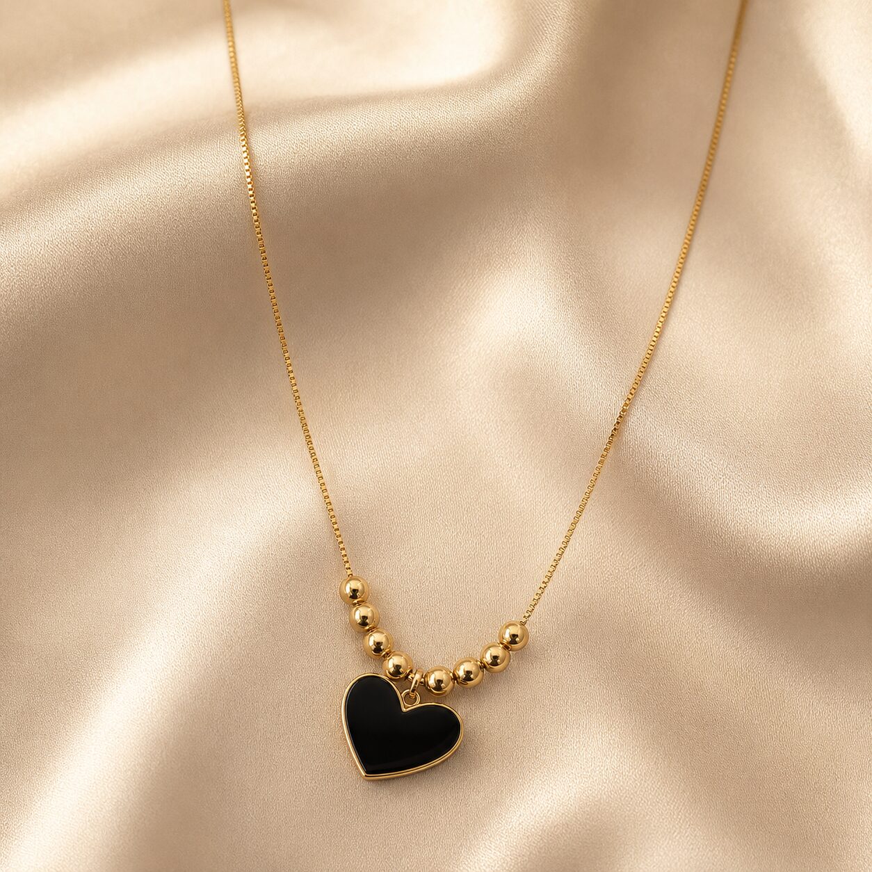 2026/08/18358.jpg Black Heart Golden Beaded Pendant Necklace - Image 1