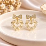 Elegant Crystal Bow & Pearl Heart Drop Earrings – Gold Finish